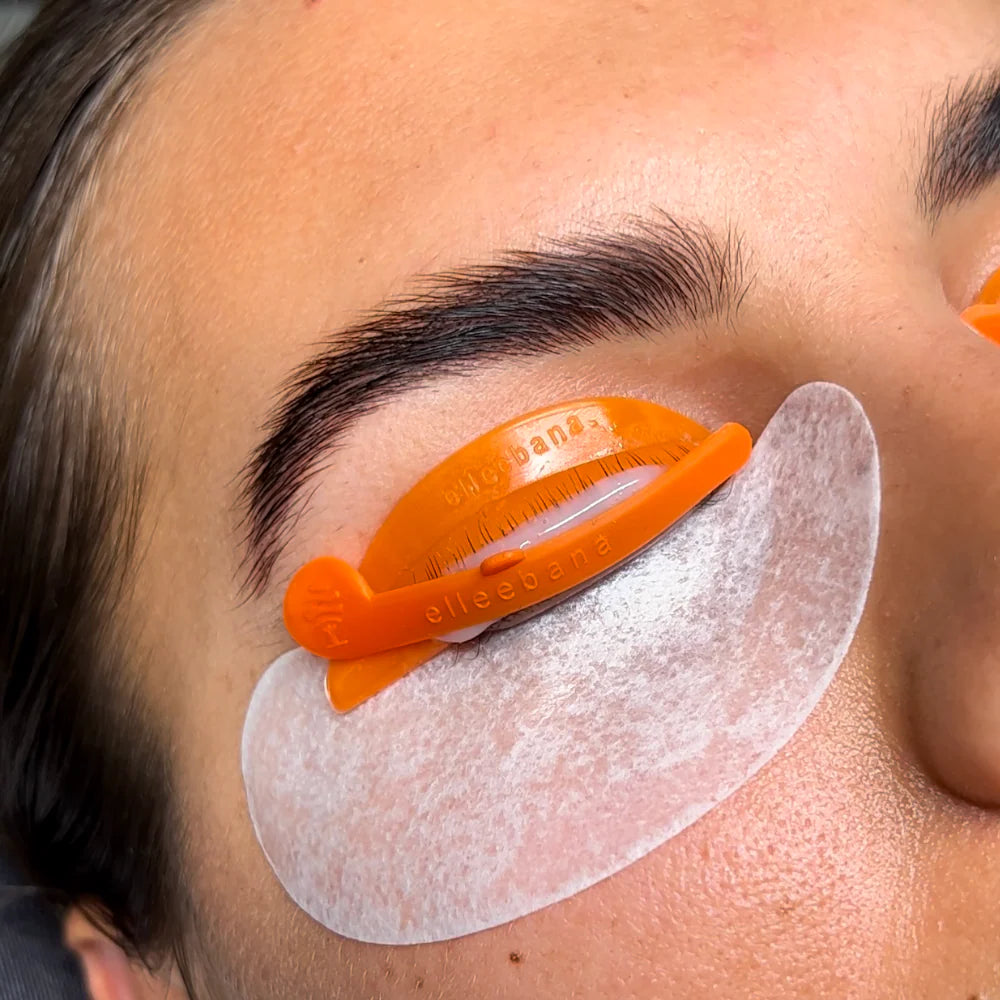 Person using an orange lift locker elleebana tool on their face