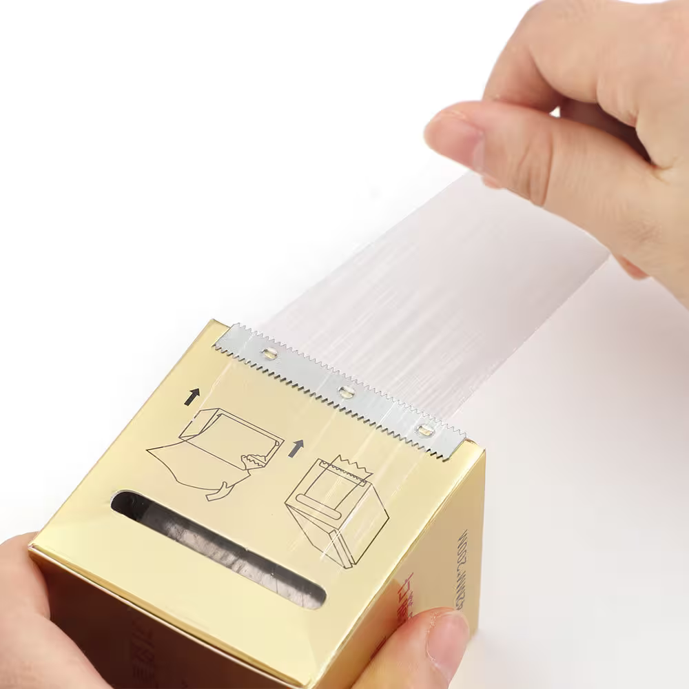 Gold box with a label being held by a hand on a white background